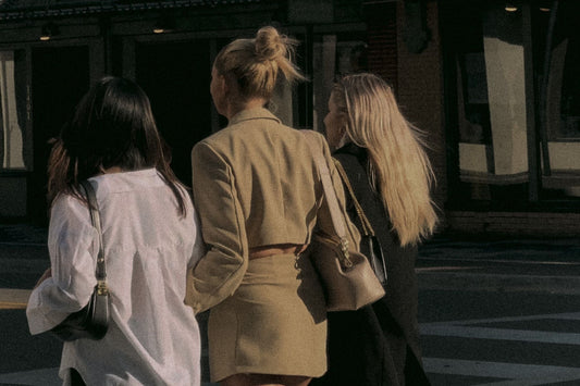 group of girlfriends walking down road arm in arm