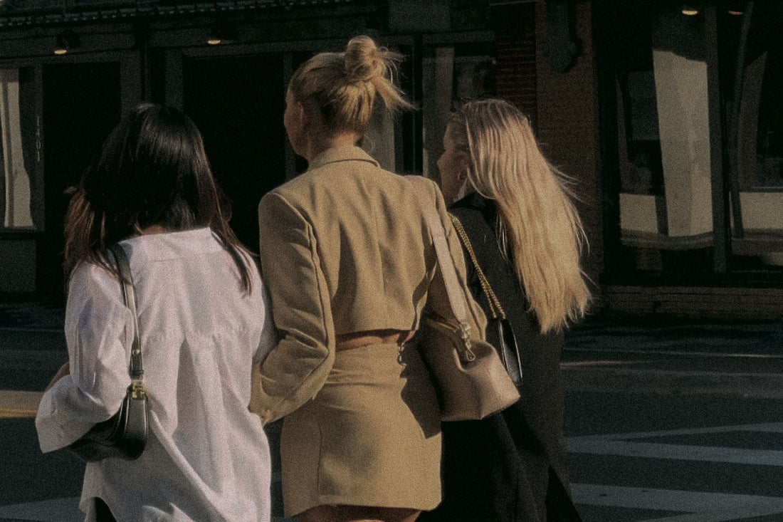 group of girlfriends walking down road arm in arm