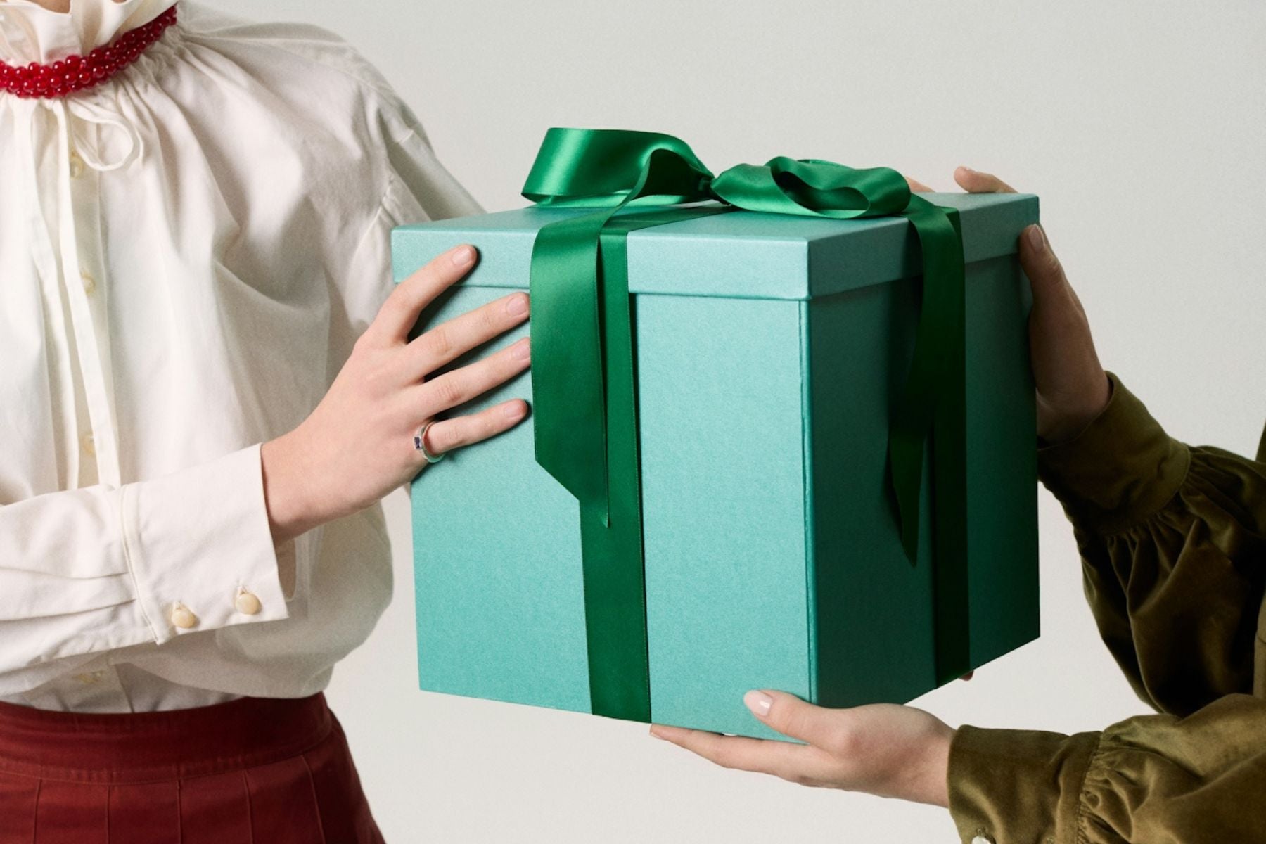 someone being handed a big green gift box