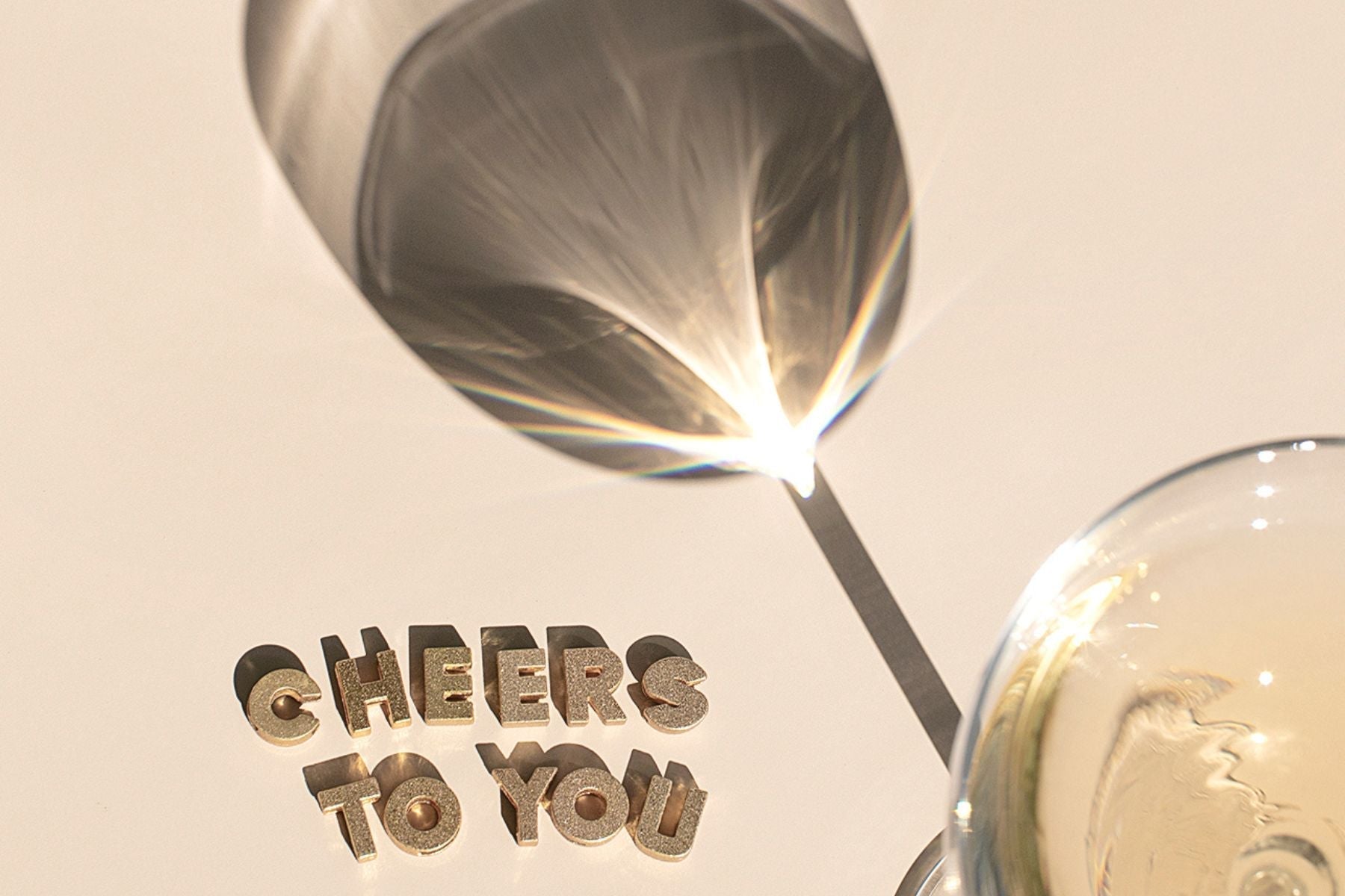 glass of champagne with words cheers to you on table