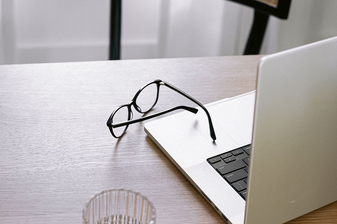 student desk with laptop, glass and glasses