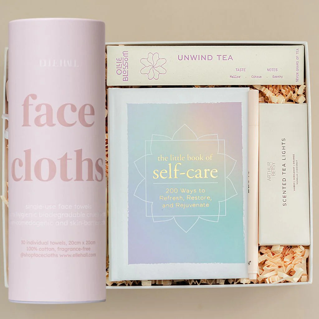 single use face cloths, unwind tea, little book of self care, tea lights, pen in a gift box